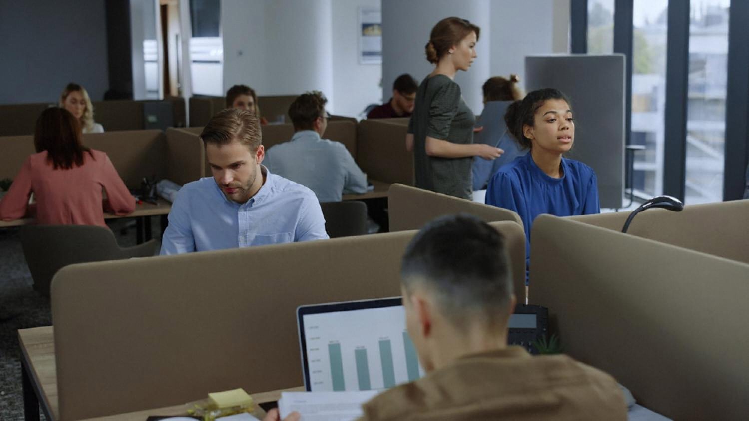 Team of office workers using computers in a shared workspace in the UAE